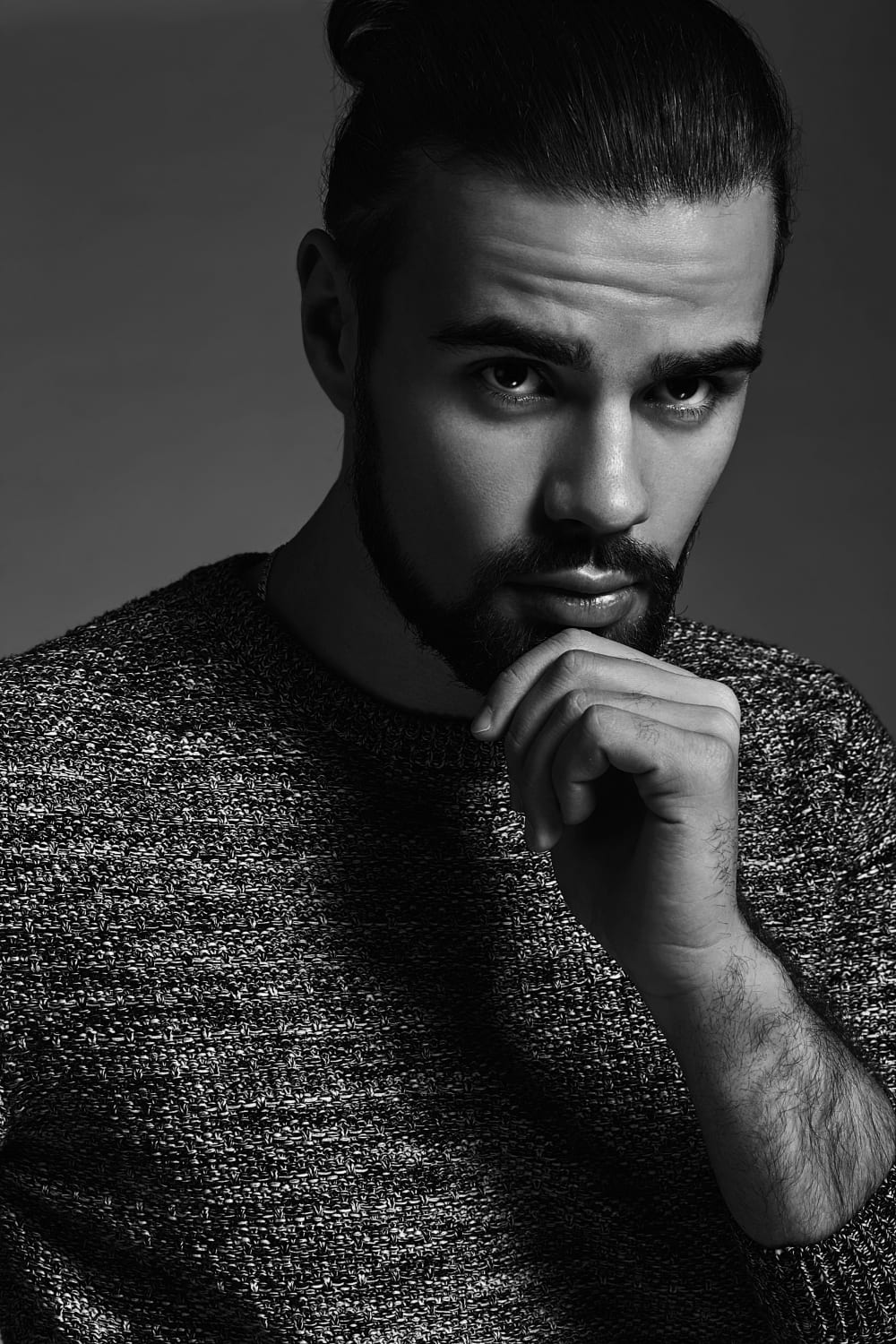 portret przystojny moda stylowy hipster model ubrany w cieply sweter pozowanie studio