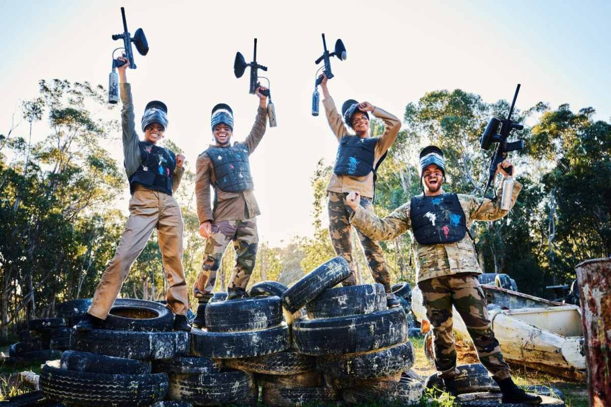team paintball portrait celebration winning victory achievement standing tires together nature group people enjoying win success teamwork with guns air sports